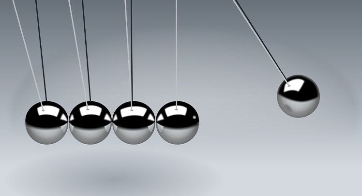 A group of balls hanging from a string on a gray background.